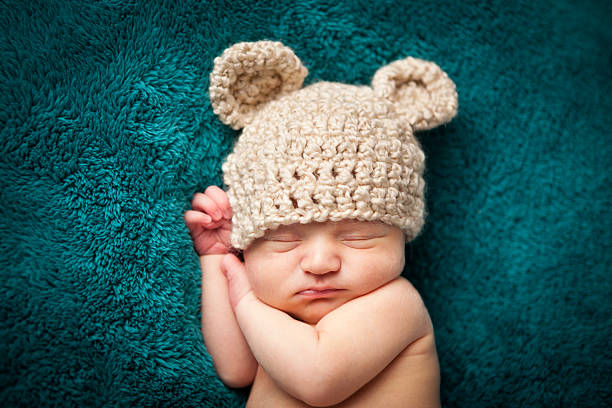 Newborn Baby Boy Sleeping Peacefully Wearing Knit Hat stock photo