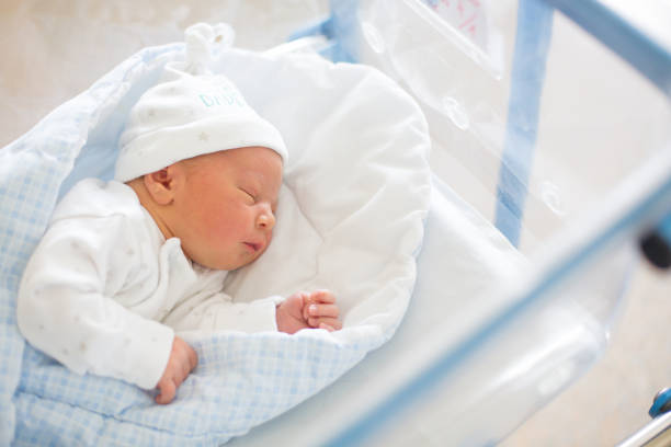 Newborn baby laying in crib in prenatal hospital stock photo