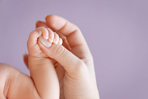 Newborn children's hand in mother hand. Mom and her Child. stock photo