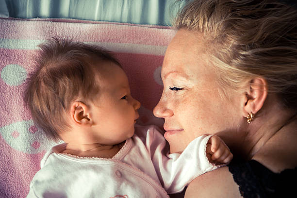 Newborn with mother looking at each other stock photo