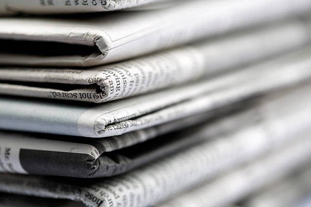 Newspapers folded and stacked concept stock photo