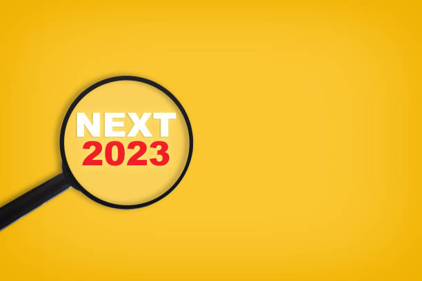 Next 2023 wrtiten on yellow paper with magnifying glass stock photo