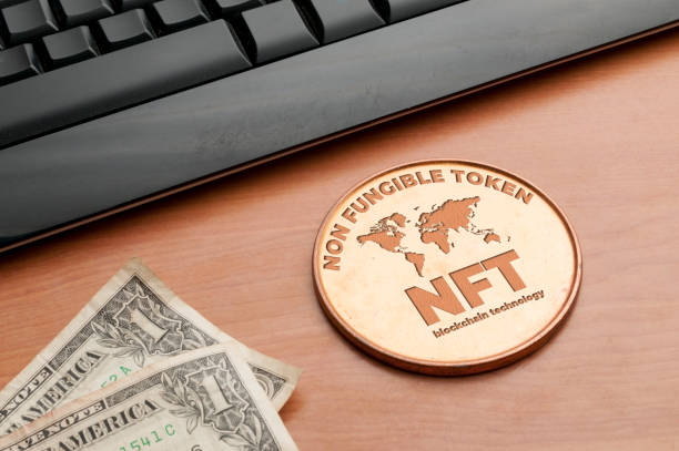 nft (не взаимозаменяемый токен) концепция: большая медная монета на деревянном столе с клавиатурой компьютера и двумя долларовыми купюрами - nft стоковые фото и изображения
