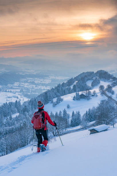 nice woman snowshoeing in the Bavarian Alps nice active senior woman snowshoeing in the Allgaeu Alps near Oberstaufen with view into the Bregenzerwald, Vorarlberg, Austria allgau alps stock pictures, royalty-free photos & images
