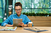 istock Nice-looking young caucasian businesswoman using tablet at the desk in modern office 1285788477