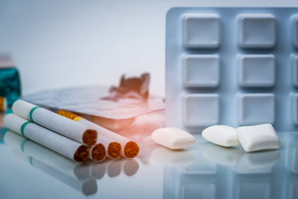 Nicotine chewing gum in blister pack near pile of cigarette. Quit smoking or smoking cessation and lung cancer concept. 31 May : World no tobacco day. stock photo