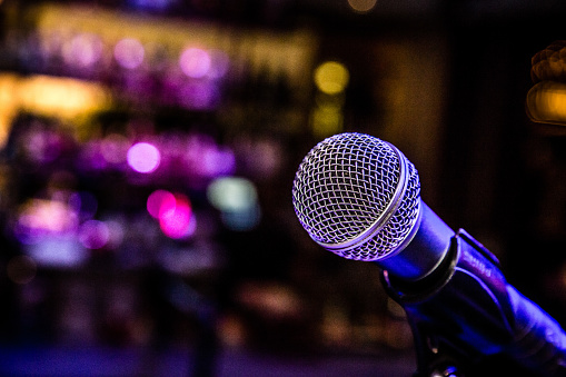 Microphone set up with lights for a comedy music show in a bar.