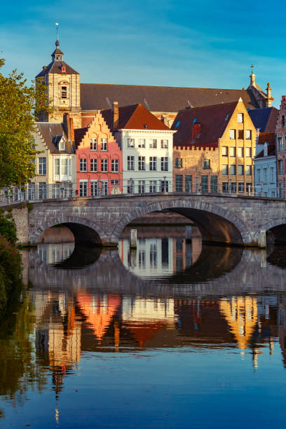Night Bruges canal and bridge, Belgium Scenic city view of Bruges canal with beautiful medieval colored houses, bridge and reflections in the evening gold hour, Belgium brugge belgium stock pictures, royalty-free photos & images