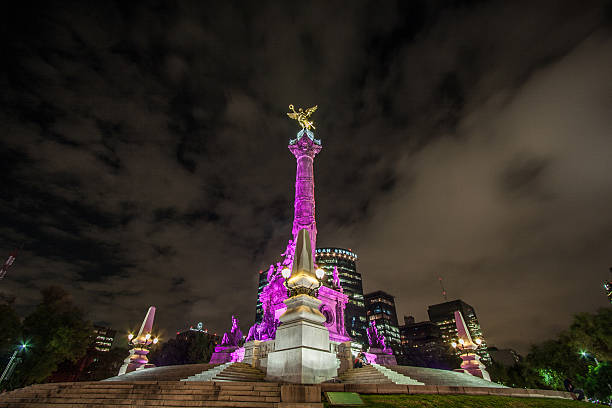 Night shot of Mexico City's landmark bathed in purple light stock photo