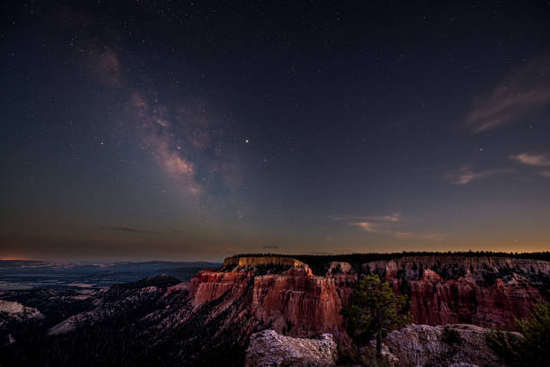 Night sky with dark milky way starscape in Bryce Canyon National Park in Utah at Pariah view overlook and rock formations panoramic viewpoint Night sky with dark milky way starscape in Bryce Canyon National Park in Utah at Pariah view overlook and rock formations panoramic viewpoint bryce canyon national park stock pictures, royalty-free photos & images