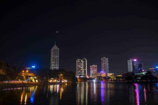 Night view long exposure landscape photo of Colombo city skyline. Reflections of the building lights are visible in the Beira Lake, Sri Lanka stock photo