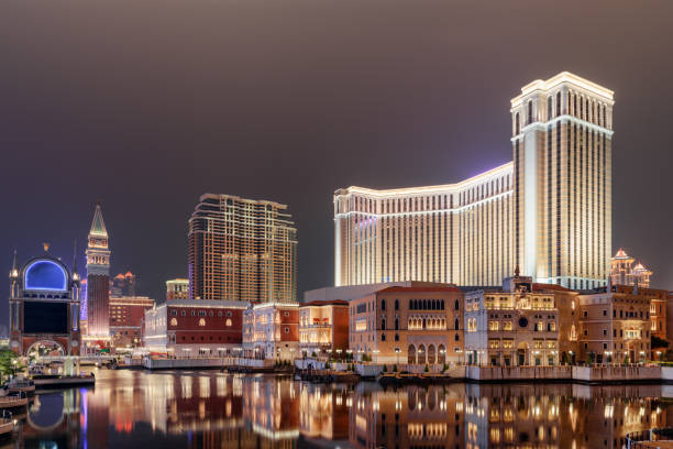 Night view of buildings in Venetian Gothic style. Cotai, Macau Macau - October 17, 2017: Wonderful night view of amazing buildings in Venetian Gothic style reflected in water in Cotai of Macau. Beautiful cityscape. Cotai is a new gambling and tourism area with casinos and shopping malls. the venetian macao stock pictures, royalty-free photos & images