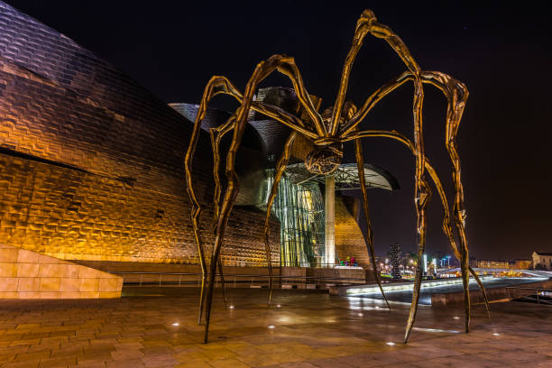Night view of Maman spider by the artist Louise Bourgeois located outside the Guggenheim Museum, Bilbao, Basque Country, Spain stock photo