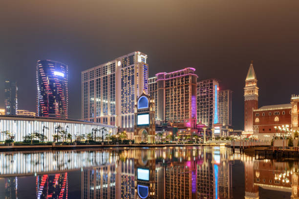 Night view of modern buildings reflected in water, Cotai, Macau Amazing night view of modern buildings reflected in water in Cotai of Macau. Beautiful cityscape. Cotai is a new gambling and tourism area with casinos and shopping malls. cotai strip stock pictures, royalty-free photos & images