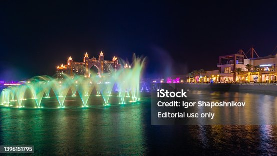 Night view to the colorful Palm Fountain at The Pointe in Palm Jumeirah, the largest fountain in Dubai and the world. The fountain also dances to famous songs from all around the globe.