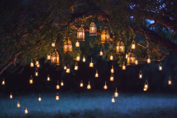 Night wedding ceremony with a lot of vintage lamps and candles on big tree stock photo
