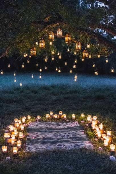Night wedding ceremony with a lot of vintage lamps and candles on big tree stock photo