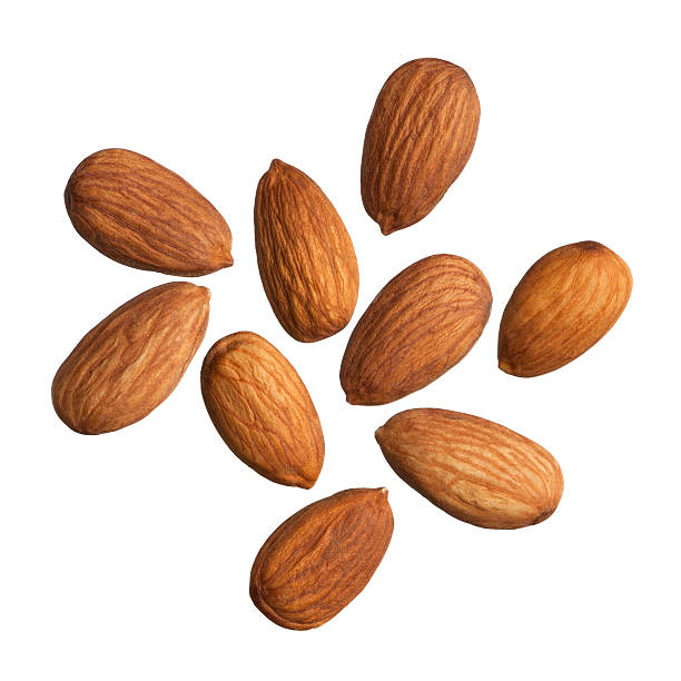 Nine scattered almonds on a white background Almonds isolated on white background. almond photos stock pictures, royalty-free photos & images