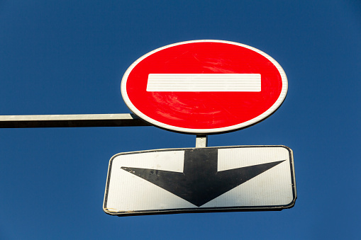 Traffic sign stop  and black arrow on blue sky background. prohibition sign