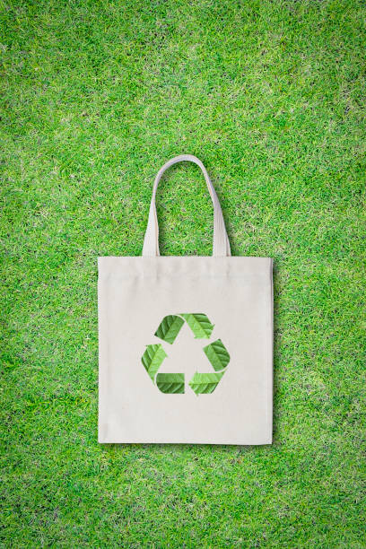keine plastiktüte, einkaufstasche konzept mit stoff sack tuch totebag mit recycling-zeichen isoliert auf grünem rasen (clipping-pfad) - sustainability fashion stock-fotos und bilder