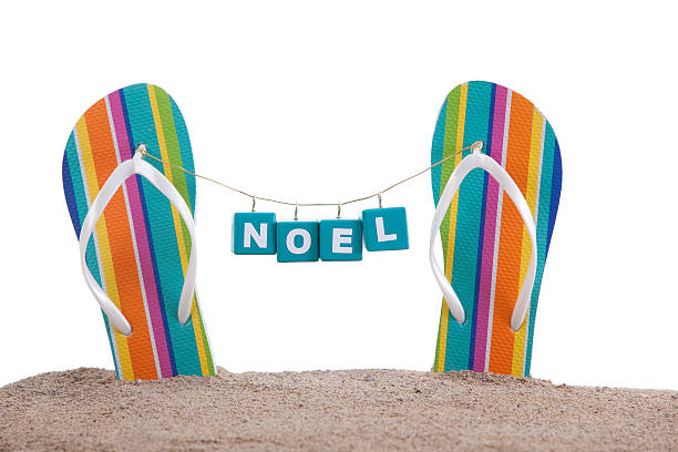 Noel Christmas Blocks Hanging From Flip Flops on a Beach stock photo