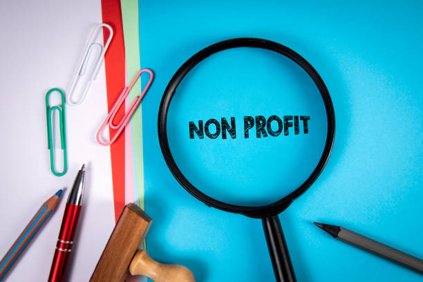 Non Profit. Magnifying glass, stationery on the office desk stock photo