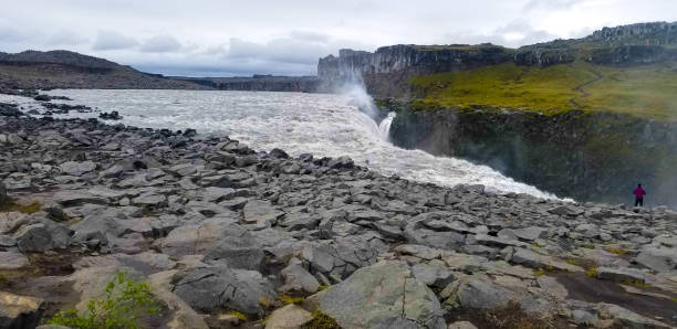 North Iceland: Adventurous Tourist At Edge of Dettifoss Waterfall North Iceland: Adventurous Tourist At Edge of Dettifoss Waterfall. dettifoss waterfall stock pictures, royalty-free photos & images
