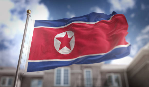 северная корея флаг 3d рендеринг на голубом небе строительство фон - north korea стоковые фото и изображения