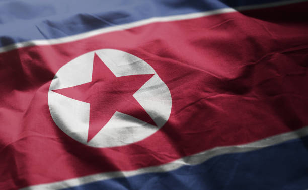 флаг северной кореи помят крупным планом - north korea стоковые фото и изображения