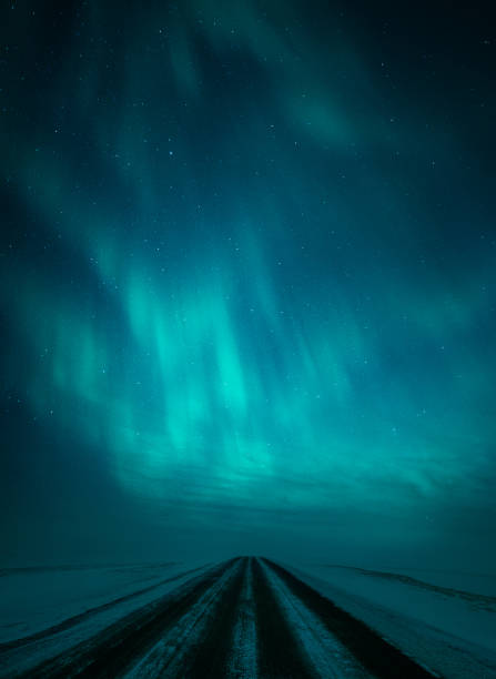 Northern lights (Aurora borealis) over frozen road in arctic winter landscape stock photo