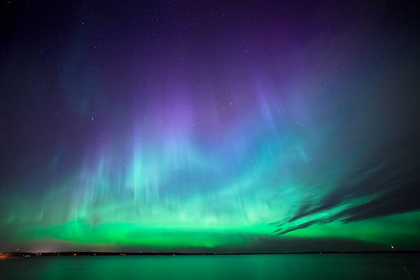 northern lights over lake in finland - northern light stockfoto's en -beelden