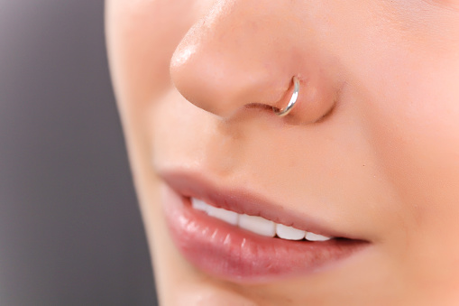 Close-up of an unrecognizable Caucasian young woman with a nose piercing.