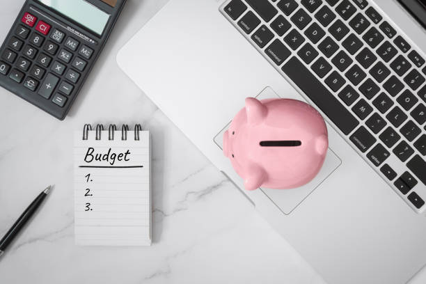 Notebook and Piggy Bank on Laptop Budget Written on Notebook and Piggy Bank on Laptop. allowance stock pictures, royalty-free photos & images