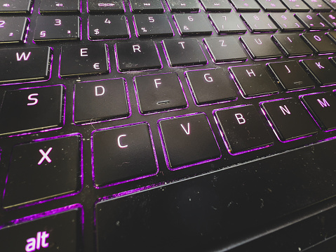 A notebook keyboard with purple light.