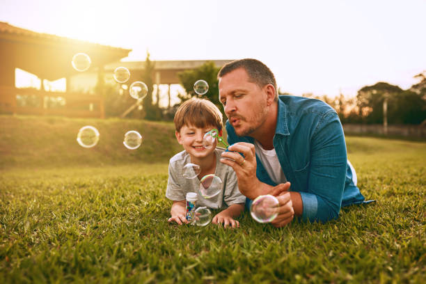 Nothing grows a father son bond like fun Cropped shot of a young family spending time together outdoors bubble wand stock pictures, royalty-free photos & images