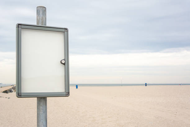 notice board on empty beach - strandbordjes stockfoto's en -beelden
