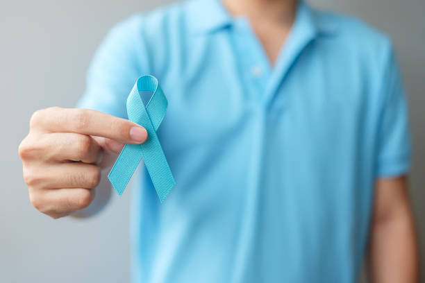 November Prostate Cancer Awareness month, Man in blue shirt with hand holding Blue Ribbon for supporting people living and illness. Healthcare, International men, Father and World cancer day concept stock photo