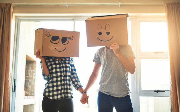 Shot of a happy young couple having fun with boxes while moving into their new house