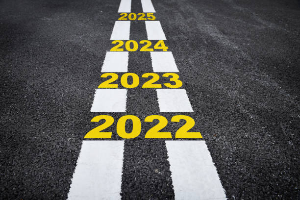 Number of 2022 to 2025 on asphalt road surface with marking lines stock photo