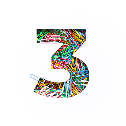 Number three of colorful rainbow paperclips, white cut paper sheet. Third numeral. Typeface. Office supplies, paperwork. High quality photo