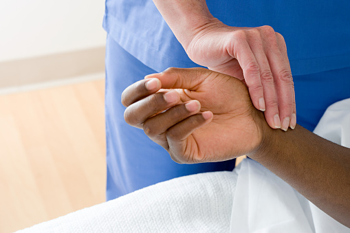 Stock Photography of Nurse checking patients pulse 