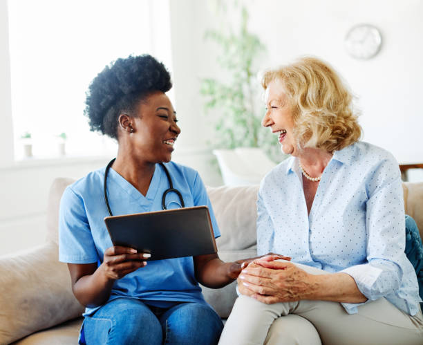 nurse doctor senior care caregiver help tablet technology retirement home nursing elderly woman health support african american black stock photo