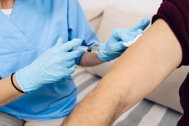Verpleegster die een Covid-19 vaccin injecteert aan een patiënt​​​ foto