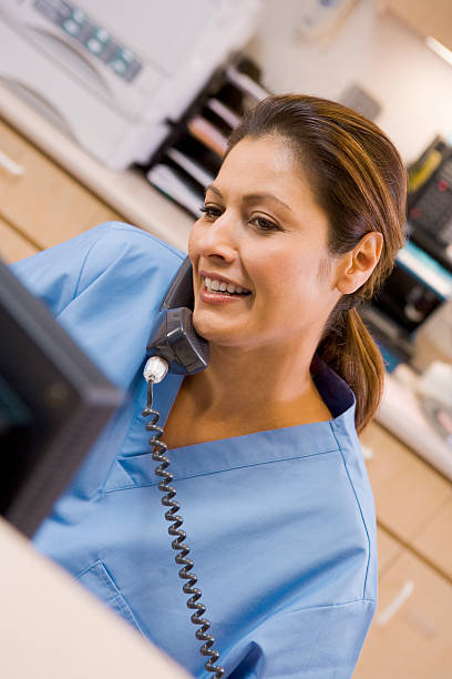 nurse on the telephone at reception area - happy scrubs nurse phone bildbanksfoton och bilder