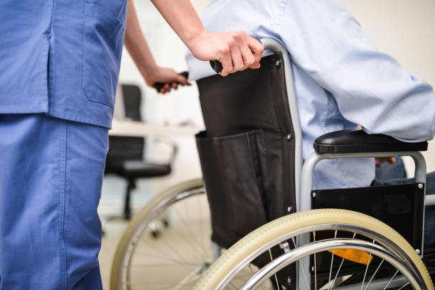Nurse pushing a wheelchair stock photo