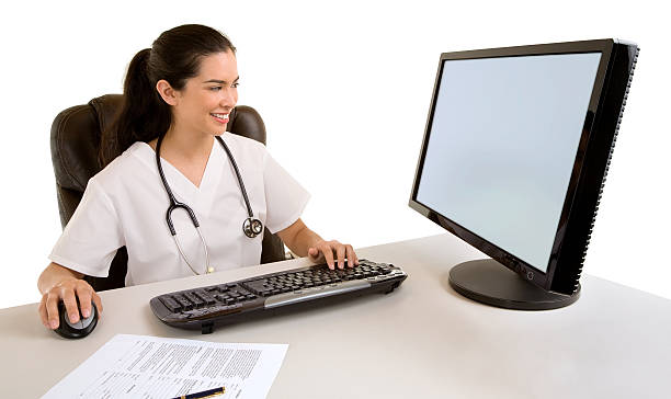 Nurse Sitting and Working at her Computer stock photo