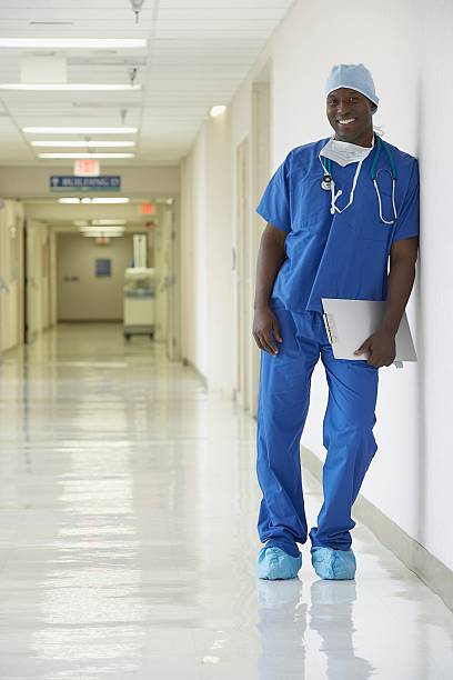 nurse standing in a hospital corridor - doctor wall imagens e fotografias de stock