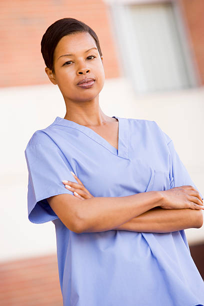 Nurse Standing Outside A Hospital Looking Seriously At Camera