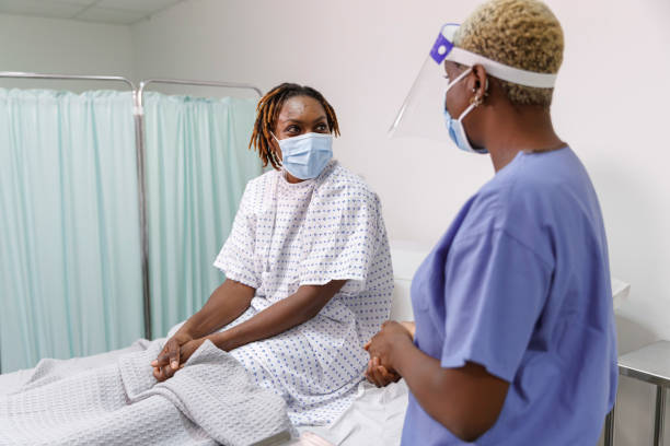 Nurse taking care of patient with COVID-19 in hospital stock photo