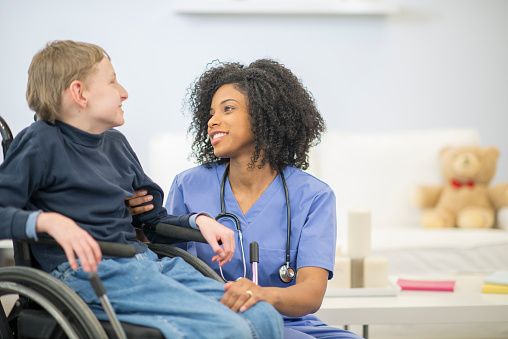 Nurse Talking To A Disabled Child Stock Photo Download